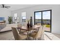 Bright dining area with wooden table, six chairs, and sliding doors leading to backyard at 6311 Chorus Dr, Mascotte, FL 34753