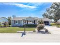 Single story home with gray siding, updated landscaping, and a screened porch at 10821 Sw 87Th Ter, Ocala, FL 34481