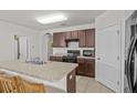 Kitchen boasts dark wood cabinets, granite countertops, and an island with seating at 5716 Lakeside Landings Blvd, Winter Haven, FL 33881