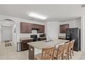 Spacious kitchen with an island, dark cabinets, and stainless steel appliances at 5716 Lakeside Landings Blvd, Winter Haven, FL 33881