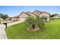 Landscaped yard with a circular driveway and a mailbox at 10929 Se 167Th Pl, Summerfield, FL 34491