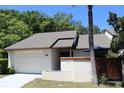 Condo exterior with a white garage door and landscaping at 2681 Washington Ave # 18, Eustis, FL 32726