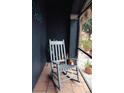 Peaceful screened porch with rocking chair and potted plants at 2019 Jaffa Ct, Clermont, FL 34714