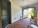 Covered front porch with brick flooring and seating at 13880 Arclid St, Orlando, FL 32832