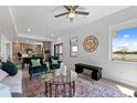 Open living room with comfortable seating, a coffee table, and large windows at 6230 Chorus Dr, Mascotte, FL 34753