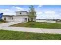Two story house with attached garage, driveway, and front yard at 6230 Chorus Dr, Mascotte, FL 34753