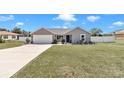 Gray house with a two-car garage and landscaped yard at 396 Marion Oaks Golf Way, Ocala, FL 34473