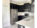 Modern kitchen with dark cabinets, stainless steel appliances, and quartz countertops at 8502 Arcadia Ln, Davenport, FL 33896