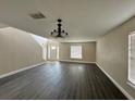 Bright living room with dark grey laminate flooring and chandelier at 104 Richmar Ave, Haines City, FL 33844