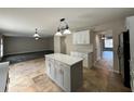 Modern kitchen with island, white cabinets and tile flooring at 104 Richmar Ave, Haines City, FL 33844