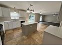 Modern kitchen featuring an island, white cabinets and tile flooring at 104 Richmar Ave, Haines City, FL 33844