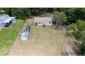 Aerial view of a mobile home on a large lot with detached shed and other structures at 22545 Orange Blossom Ln, Eustis, FL 32736