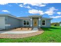 Single-story home with gray exterior, yellow door and manicured lawn at 6260 Sw 144Th Lane Rd, Ocala, FL 34473