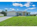 Single-story home with gray exterior, attached garage, and manicured lawn at 6260 Sw 144Th Lane Rd, Ocala, FL 34473