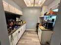 Kitchen with white cabinets and laminate flooring at 34 Saint Andrews Ct, Kissimmee, FL 34759