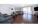 Spacious living room featuring hardwood floors, sectional sofa, and large window at 15223 Windmill Harbor Ct, Orlando, FL 32828