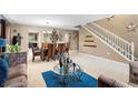 Open concept living room and dining area, featuring a staircase and large windows at 3227 Shingler Ter, Deltona, FL 32738