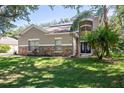 Two-story house with stone accents and solar panels at 1301 Kintla Rd, Apopka, FL 32712