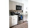 Modern kitchen with stainless steel appliances and light cabinets at 605 Oakpoint Cir, Davenport, FL 33837