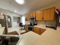 Kitchen with wood cabinets, stainless steel appliances, and tile floors at 185 Winding Cove Ave, Apopka, FL 32703