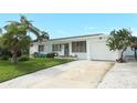 Mid-century modern home with white exterior and driveway at 31 Tropical Dr, Ormond Beach, FL 32176