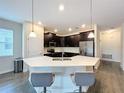 Modern kitchen with dark cabinets, white countertops, and island at 1065 Blackwolf Run Rd, Davenport, FL 33896