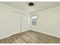 Bright bedroom with wood-look floors and double doors at 5467 Vineland Rd # 6308, Orlando, FL 32811