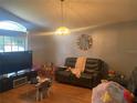 Bright living room with hardwood floors, large TV, and ample seating at 4336 Cypress Bay Ct, Orlando, FL 32822