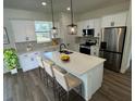 Modern kitchen with white cabinets, quartz countertops, and stainless steel appliances at 2827 Sw 146Th Place Rd, Ocala, FL 34473