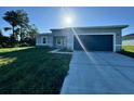 Modern single-story home with gray exterior, two-car garage, and grassy lawn at 13053 Sw 36Th Ct, Ocala, FL 34473