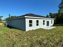 Rear view of a single-story home with gray exterior and sliding glass door at 13053 Sw 36Th Ct, Ocala, FL 34473