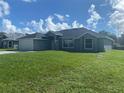 Newly built home with a grey exterior and large yard at 541 Rhodes Dr, Deland, FL 32720