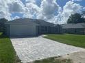 Newly built home with a grey exterior and a paver driveway at 541 Rhodes Dr, Deland, FL 32720