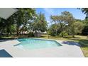 Inviting pool with spacious deck, surrounded by lush landscaping and a storage shed at 1801 James St, South Daytona, FL 32119