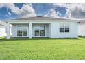 Rear view of a house with a covered patio and grassy lawn at 2476 Pine Preserve Ct, St Cloud, FL 34771