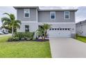 Two-story house with gray siding, white garage door, and landscaping at 14007 Creek Harbor Dr, Orlando, FL 32824