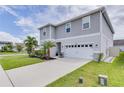 Two-story house with gray siding, white garage door, and landscaping at 14007 Creek Harbor Dr, Orlando, FL 32824