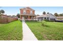 Two-story house with walkway, green grass, and a wooden fence at 1012 S Holly Ave, Sanford, FL 32771
