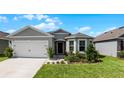 Two-story home with gray siding, white door, and landscaping at 2716 Fieldbrooke Way, Edgewater, FL 32141