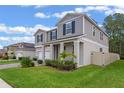 Two-story house with gray siding, white garage door, and landscaped yard at 2864 Sanctuary Dr, Clermont, FL 34714