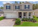 Two-story house with gray siding, white garage door, and landscaped yard at 2864 Sanctuary Dr, Clermont, FL 34714