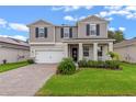 Two-story house with gray siding, white garage door, and landscaped yard at 2864 Sanctuary Dr, Clermont, FL 34714