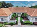 Front entrance of a house with tile roof, landscaping, and walkway to the entrance at 1185 Coachwood Ct, Longwood, FL 32779