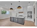 Modern kitchen with a large island, white cabinets, and gold pendant lights at 1917 S Lakemont Ave, Winter Park, FL 32792