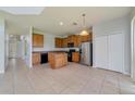 Open kitchen features an island, stainless steel appliances, and wood cabinets at 2839 Boating Blvd, Kissimmee, FL 34746