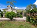 Two-story house exterior with stone accents and palm trees at 25013 Derby Dr, Sorrento, FL 32776