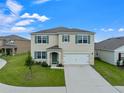 Two-story house with a two-car garage, landscaping, and a teal front door at 821 Sun Burst Rd, Winter Haven, FL 33880
