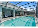 Private screened-in pool and spa with plenty of lounge chairs at 3625 Lily Ln, Davenport, FL 33897