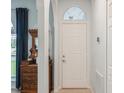 Bright entryway with white door, arched entry, and antique furniture at 815 Cardinal Way, Poinciana, FL 34759