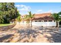 Two-story house with tile roof, large driveway, and landscaping at 8605 Bay Shore Cv, Orlando, FL 32836
